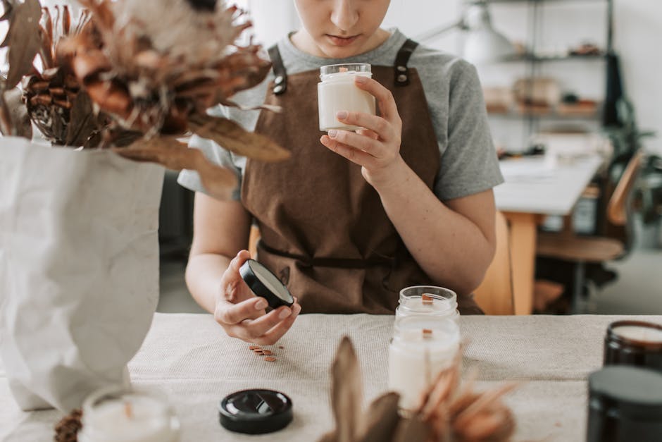 A woman crafting candles in a rustic workshop, focusing on scents and quality.